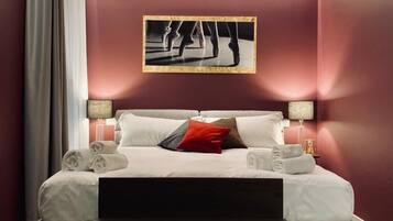 Relax in a stylish space with a large bed, bedside tables, and a framed photograph above.