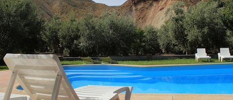 Una piscina al aire libre de temporada, sombrillas