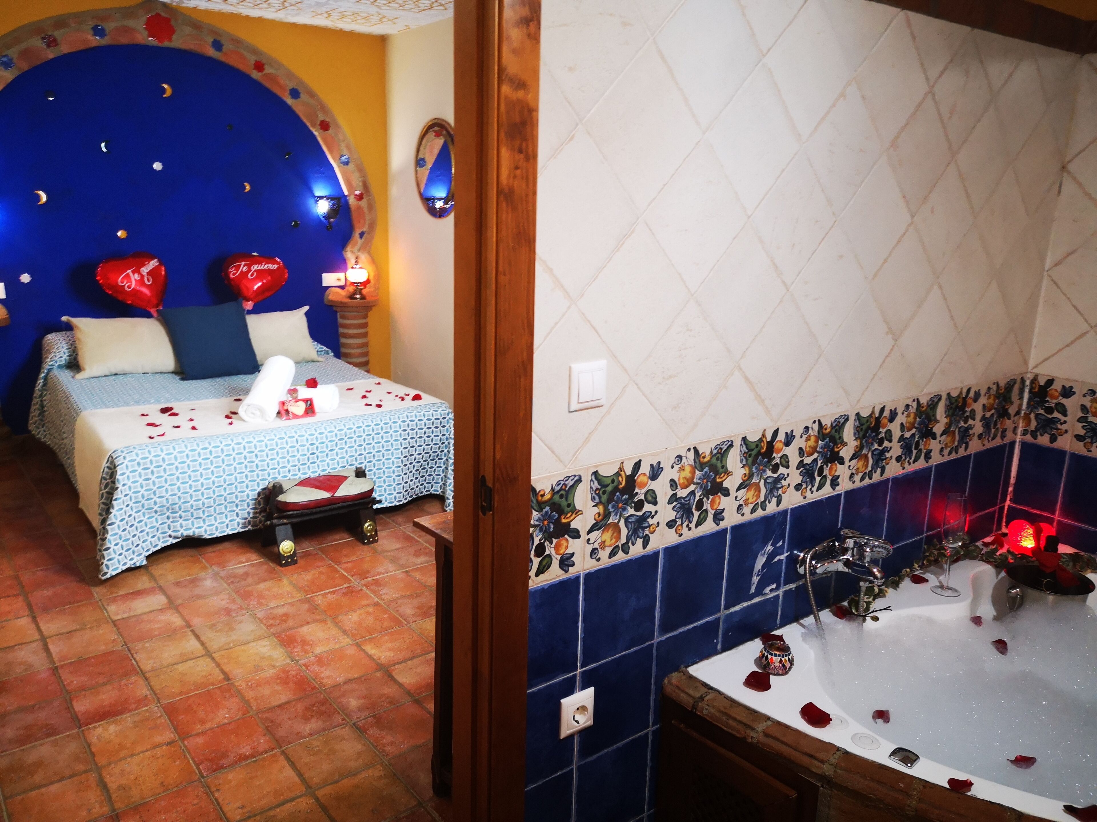 Un dormitorio con cama, mesita de noche y velador.