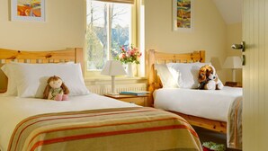 Een hotelkamer met twee bedden, een raam met uitzicht en een lamp aan beide kanten.