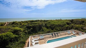 A pool area with lounge chairs and a view of the ocean. - OCEANFRONT, Ocean views, Rec Rm, Private Pool, Hot Tub, PI52, Coco Palms (Corolla)