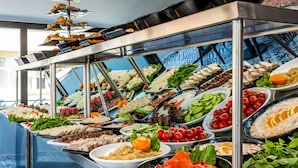 Un buffet proposant une variété de plats et une présentation de desserts en étages.