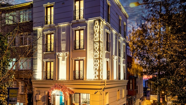 Un hôtel à la façade classique, doté de grandes fenêtres et d’une entrée imposante.