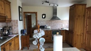 Eine Küche mit Holzschränken, einer Mikrowelle, einem Toaster und einer Kaffeemaschine.