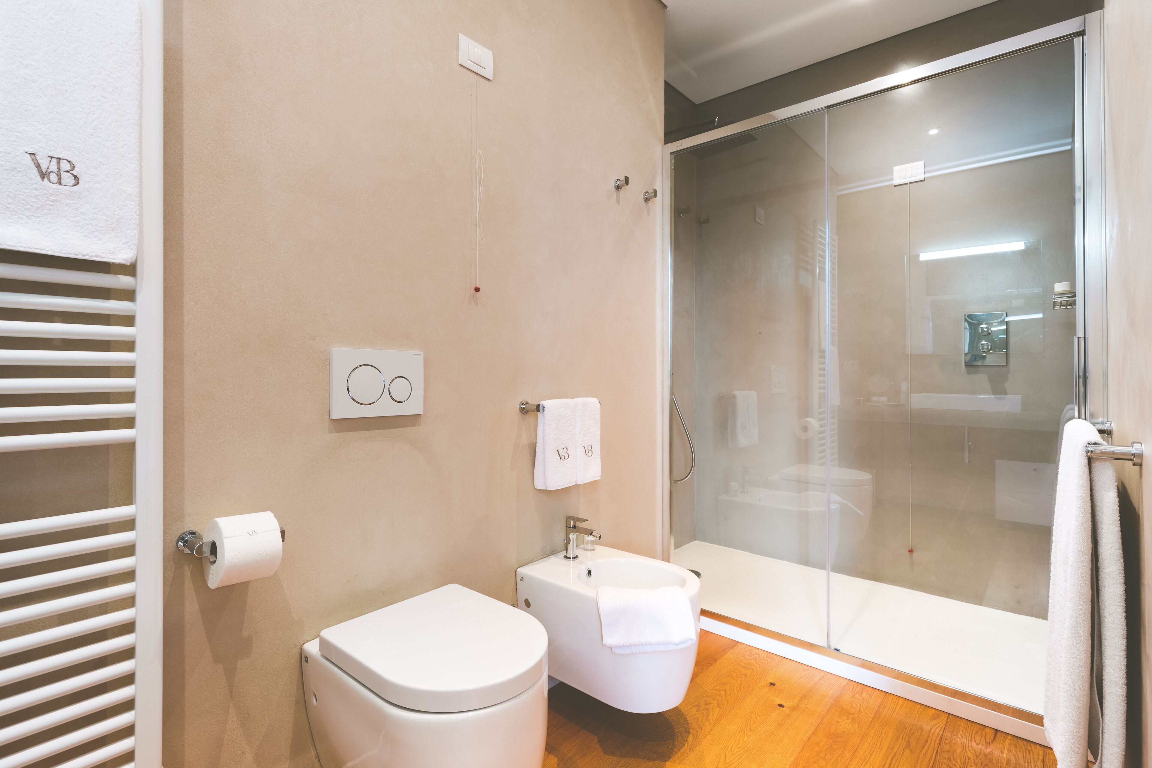 Une salle de bain moderne équipée de toilettes, d’un bidet et d’une douche à parois de verre.
