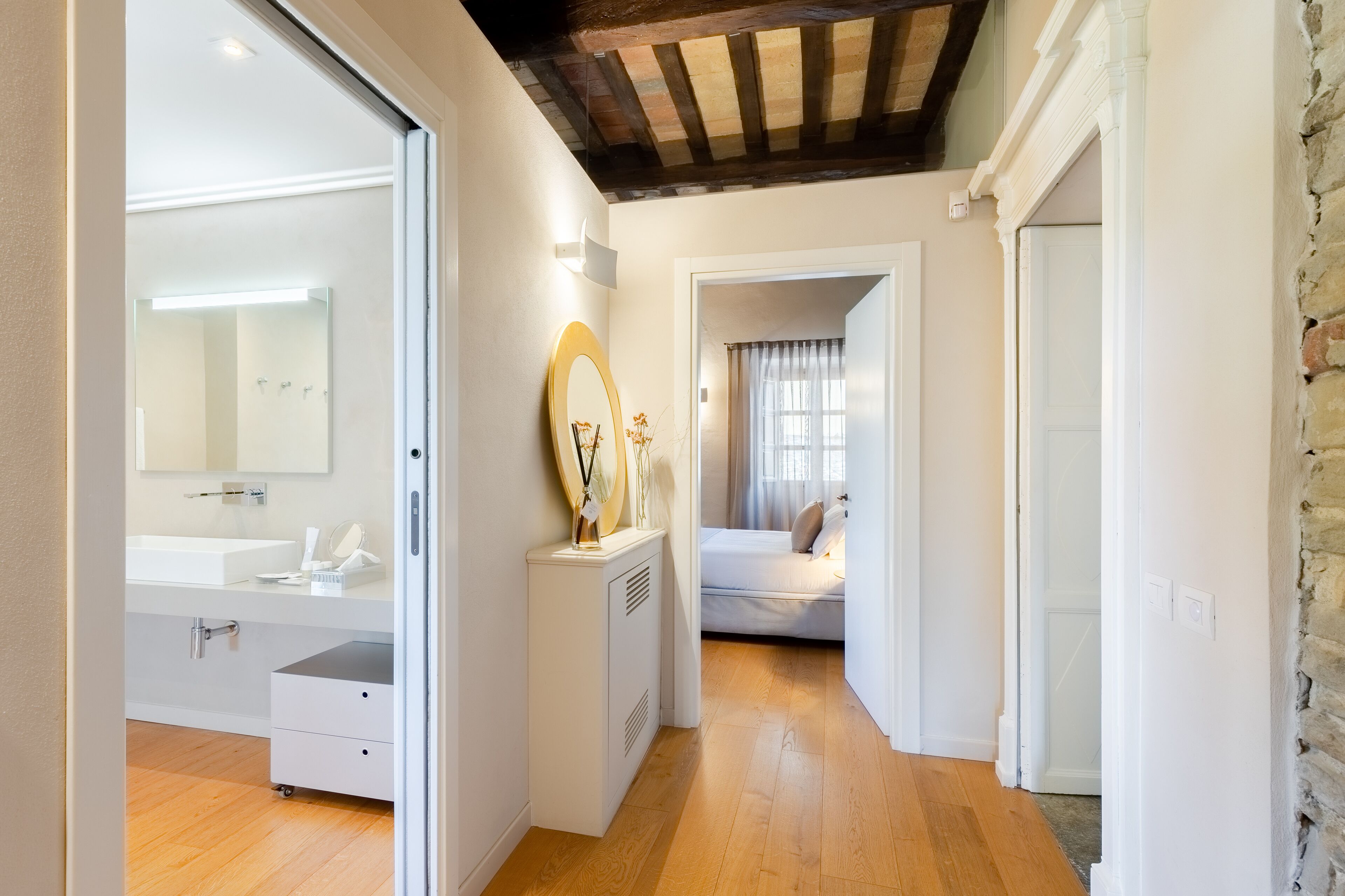 Une salle de bain moderne avec un grand miroir, un lavabo blanc et des toilettes compactes.