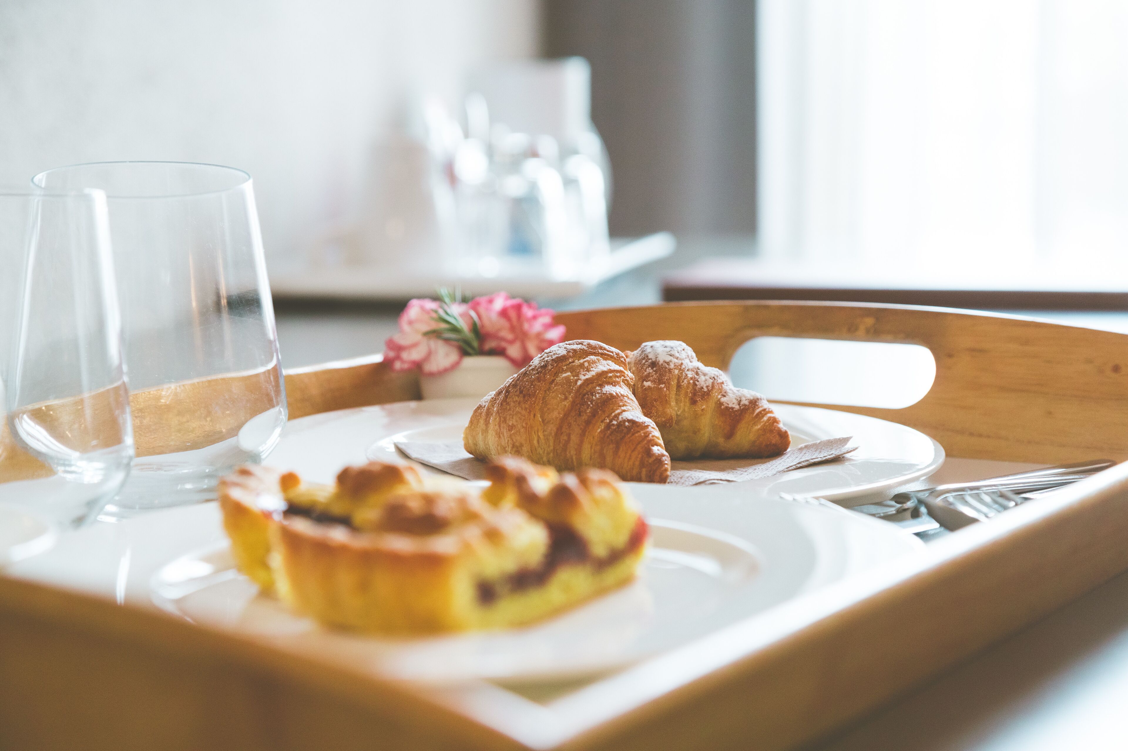 A tray with pastries and a glass of water on a table.