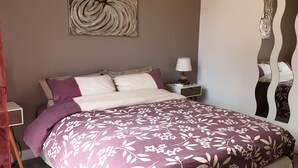 A bedroom with a bed, a nightstand, a lamp, and a wall art piece. - PORTICCIO QUIET AND CLIMATE VILLA 5 MIN FROM FOOT OF AGOSTA BEACH (Albitreccia)
