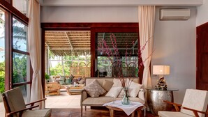 A spacious living room with a sofa, two armchairs, a coffee table, and a decorative vase. - Villa Gita Segara (Manggis)