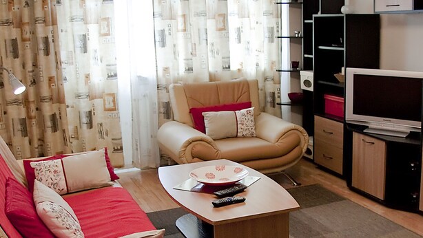 Een woonkamer met een bank, fauteuil, salontafel en tv-meubel.
