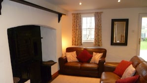 A living room with a fireplace, two leather sofas, and a large mirror on the wall. - Ballyvaughan No 7 (Ballyvaughan)