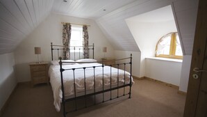 A bedroom with a single bed, a nightstand, a lamp, and a window with curtains. - Ballyvaughan No 7 (Ballyvaughan)
