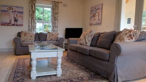 A living room with two grey sofas, a white coffee table, and a patterned rug. - Ballyvaughan Cottage No 14 (Ballyvaughan)