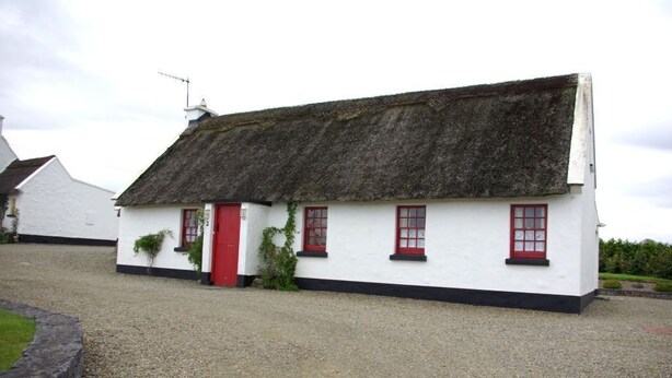 A traditional white cottage with a thatched roof, red door, and windows. - Ballyvaughan Cottage No 2 (Ballyvaughan)