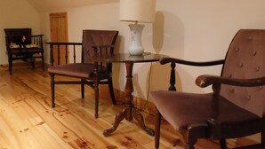 A dining area with a wooden table and two chairs, a lamp, and a wooden floor. - Ballyvaughan Cottage No 2 (Ballyvaughan)