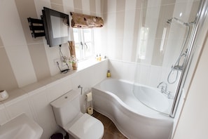 Un baño moderno con una bañera independiente, inodoro, lavabo y ducha.