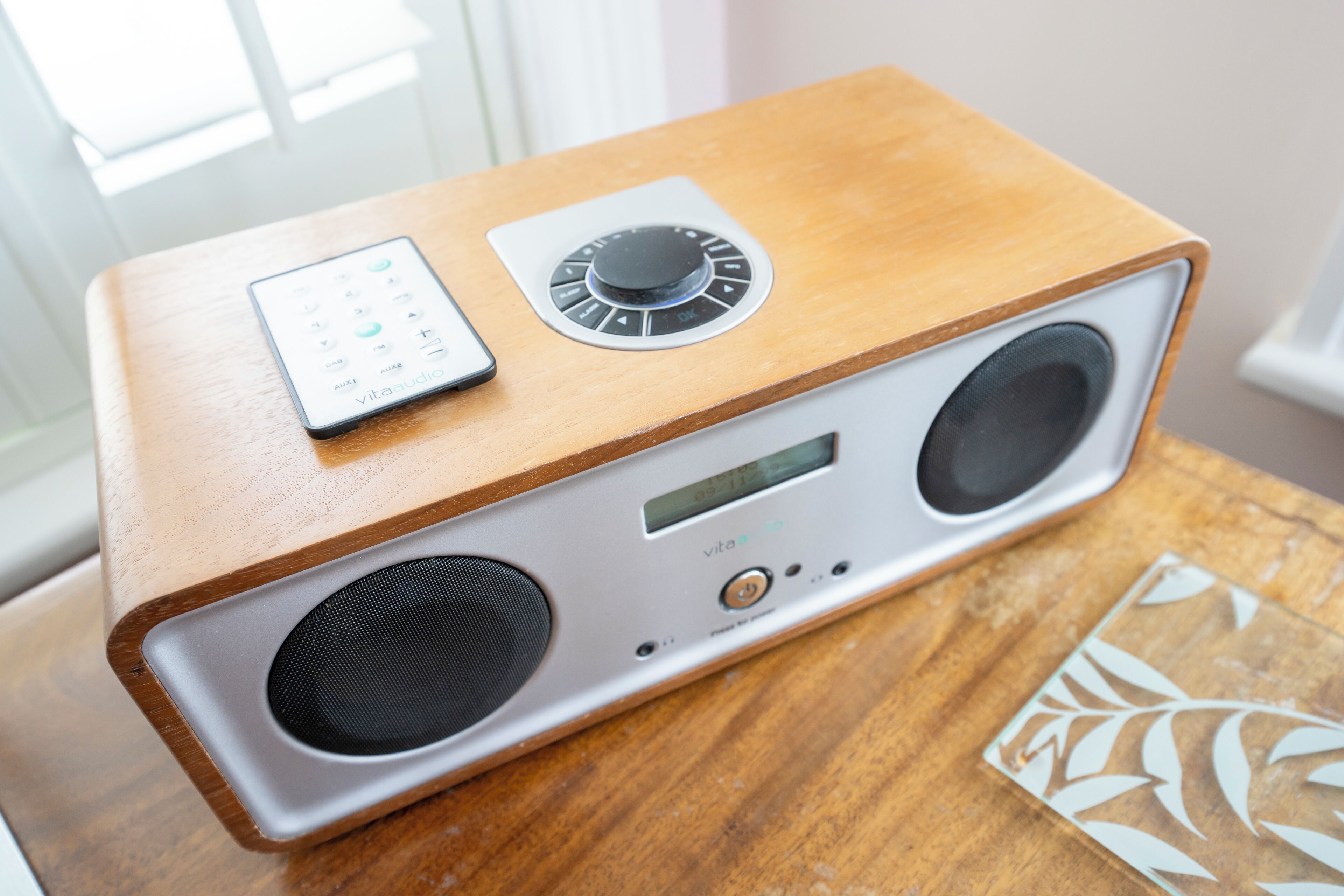 Un altavoz de madera con pantalla digital y panel de control.