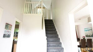 A staircase with a white railing leading to a landing. - Castle Gardens 3 bed 4052 (Bunratty)