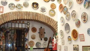 A room with a tiled wall, a guitar, and various decorative plates. - Hostal Alcazar I (Córdoba)