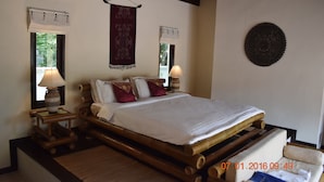 A room with a bed, two bedside lamps, a window with a curtain, a wall hanging, and a ceiling fan. - 3 Bedroom pool villa 2 SDV023-By Samui Dream Villas (Koh Samui)