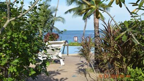 A pathway leading to a beach with palm trees and a white lounge chair. - 3 Bedroom pool villa 2 SDV023-By Samui Dream Villas (Koh Samui)
