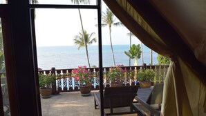 A balcony with a view of the ocean, potted plants, and a wooden bench. - 4 bedroom beachfront Villa 3 SDV024-By Samui Dream Villas (Koh Samui)