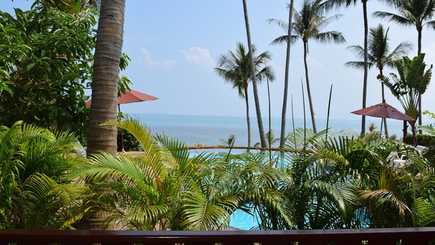 A tropical resort with a pool, palm trees, and a view of the ocean. - 4 bedroom beachfront Villa 3 SDV024-By Samui Dream Villas (Koh Samui)