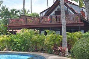 A two-story building with a balcony overlooking a pool area, surrounded by lush tropical vegetation. - 4 bedroom beachfront Villa 3 SDV024-By Samui Dream Villas (Koh Samui)