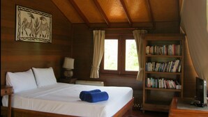 A wooden room with a bed, a bookshelf, and a painting on the wall. - 4 Bedroom Villa 4 SDV025-By Samui Dream Villas (Koh Samui)