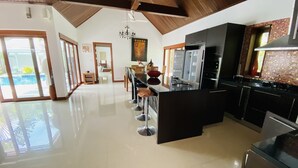 A spacious kitchen with a high ceiling, modern appliances, and a dining area with a view of the outdoors. - 3 Bedroom Villa - just 3 minutes walk to the beach SDV033-By Samui Dream Villas (Koh Samui)