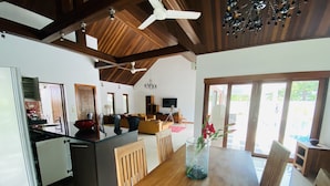 A spacious living area with a wooden dining table, a kitchen with a modern stove, and a ceiling fan. - 3 Bedroom Villa - just 3 minutes walk to the beach SDV033-By Samui Dream Villas (Koh Samui)