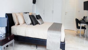 Ett sovrum med en säng, ett nattduksbord och ett skrivbord med en stol.