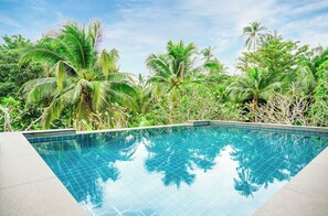 A rectangular swimming pool with clear blue water, surrounded by lush greenery and palm trees. - 2 Bedroom Villa Nature SDV004-By Samui Dream Villas (Koh Samui)