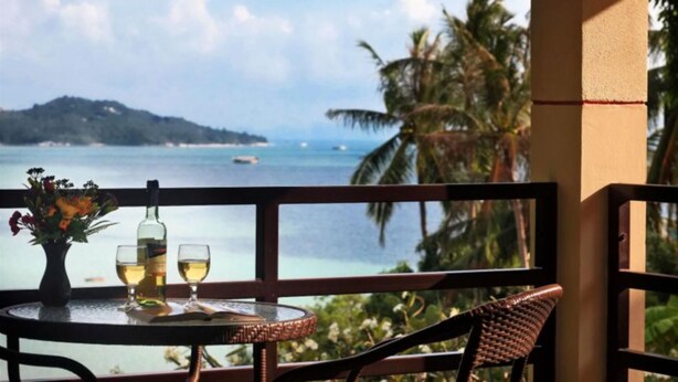 A balcony with a table set for two, overlooking a beach with palm trees and a distant island. - 6 Bedroom Bay & Island View Twin Villa Koh Phangan SDV233/234-By Samui Dream Villas  (Ko Pha-ngan)
