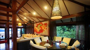 A dining area with a round table, chairs, and a large painting on the wall. - 10 Bedroom Sea Front Twin Villa Koh Phangan SDV232/234-By Samui Dream Villas (Ko Pha-ngan)