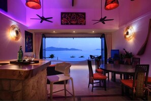 A dining area with a view of the sea, featuring a bar, chairs, and a table. - 11 Bedroom Sea Front Triple Villas Koh Phangan SDV231/233/234-By Samui Dream Villas (Ko Pha-ngan)