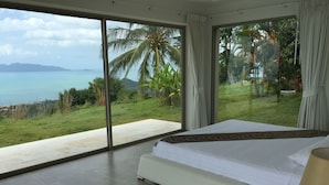 A bedroom with a large bed, a nightstand, and a view of the ocean and greenery. - 16 Bedroom Sea View Triple Villas Angthong Hills SDV205/SDV227/SDV190-By Samui Dream Villas (Koh Samui)