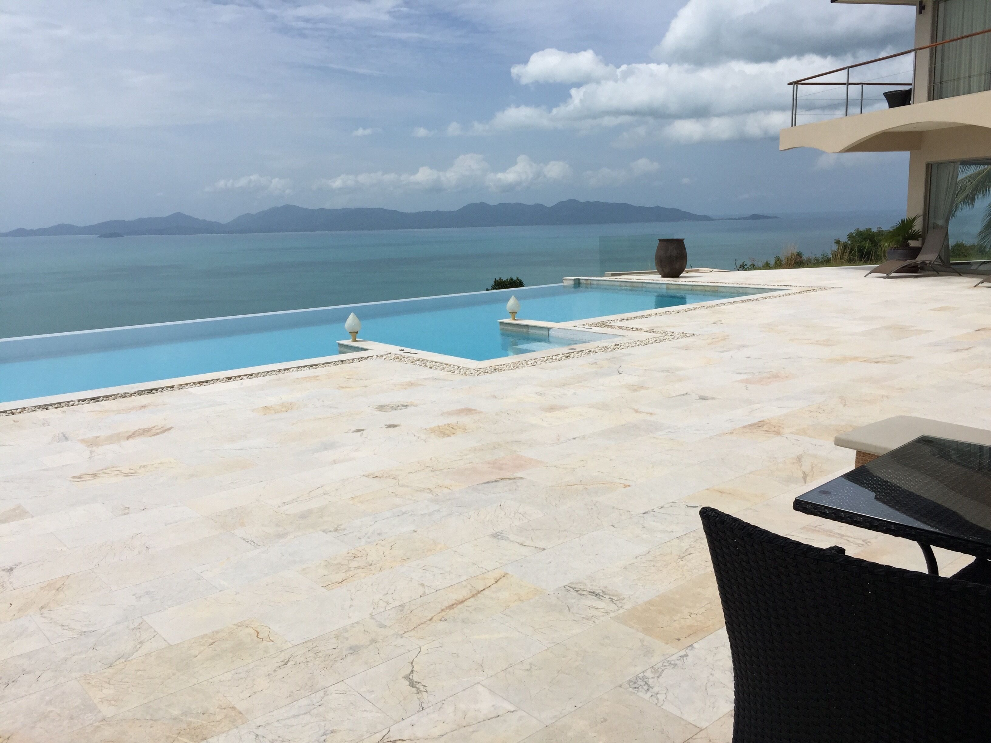 A swimming pool with a view of the sea and mountains.