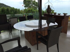 A round glass table with wicker chairs, a hanging light fixture, and a view of the sea. - 16 Bedroom Sea View Triple Villas Angthong Hills SDV205/SDV227/SDV190-By Samui Dream Villas (Koh Samui)