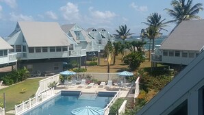 Un resort con piscina, sillas de descanso y palmeras.