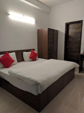 Un dormitorio con una cama grande, un armario y una puerta.