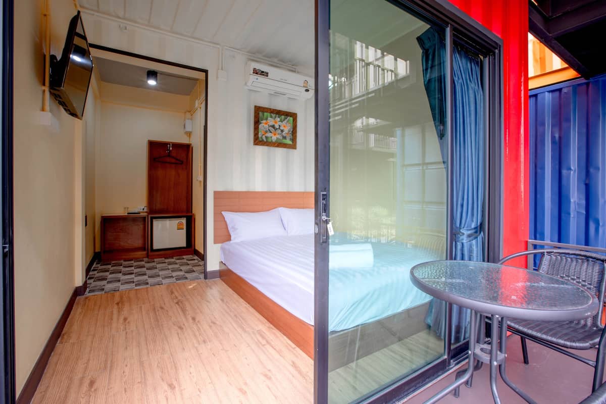 Une chambre d’hôtel équipée d’un lit, d’une petite table, d’un téléviseur et d’un appareil de climatisation.