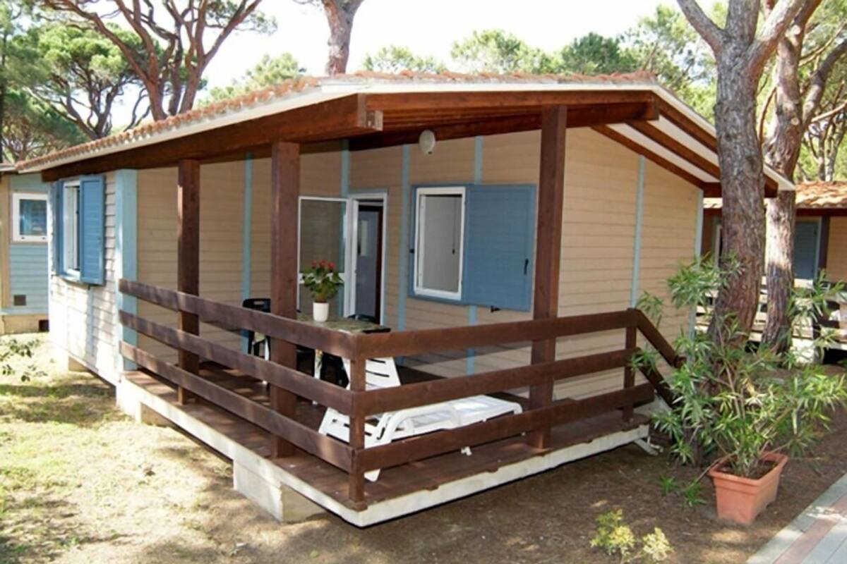 A single-story wooden cabin with a porch, a door, and a small window.