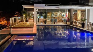 A modern building with a pool, outdoor seating, and a restaurant area. - Regina City Hotel (Vlorë)