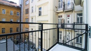 Un immeuble à plusieurs étages doté de balcons et d’une rambarde en métal.