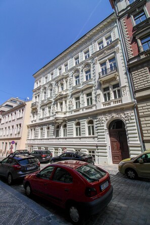 Ein mehrstöckiges Gebäude mit aufwendigen architektonischen Details, darunter Säulen und dekorative Verzierungen.