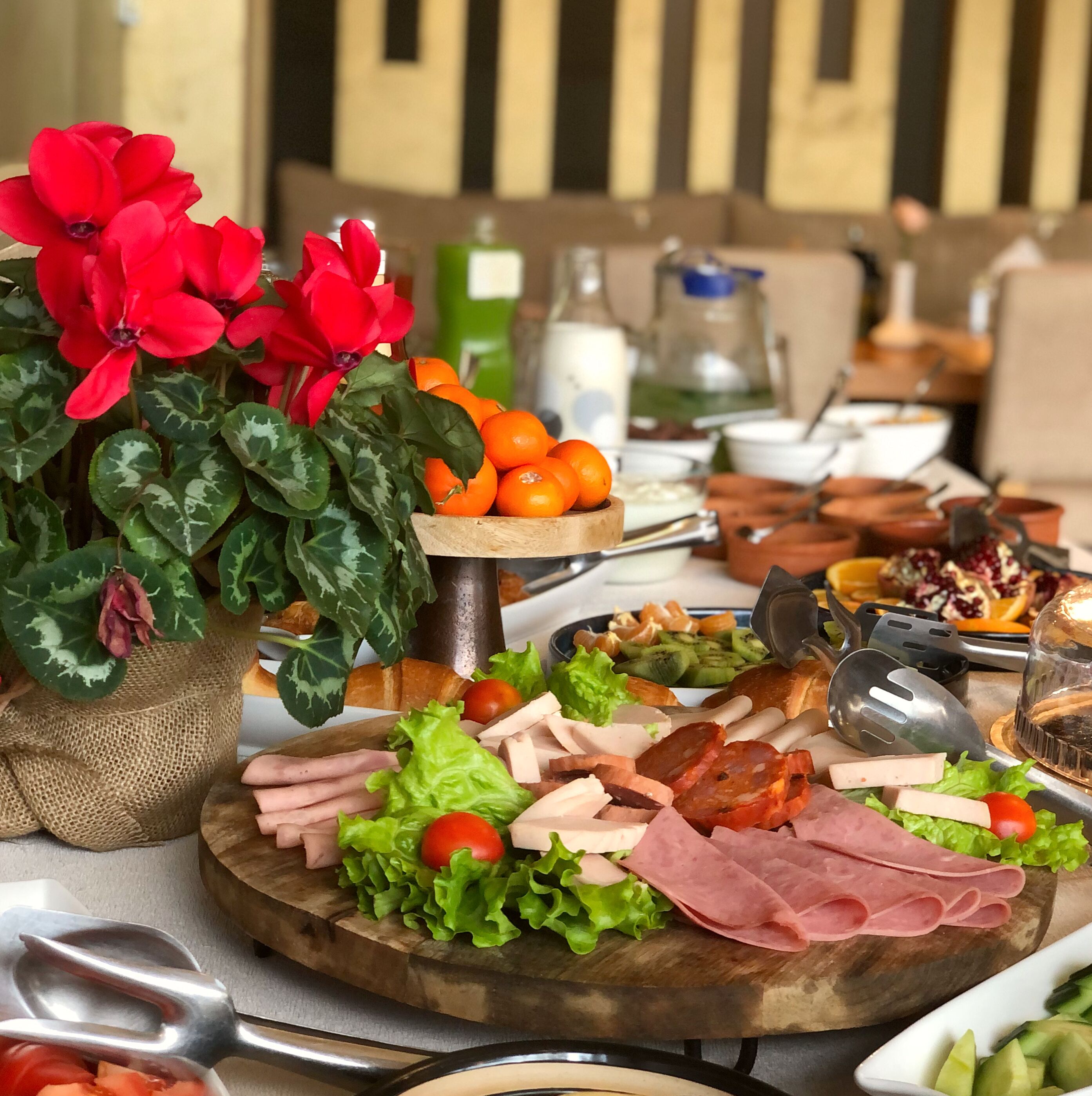 A buffet table with various food items, including meats, vegetables, and fruits.