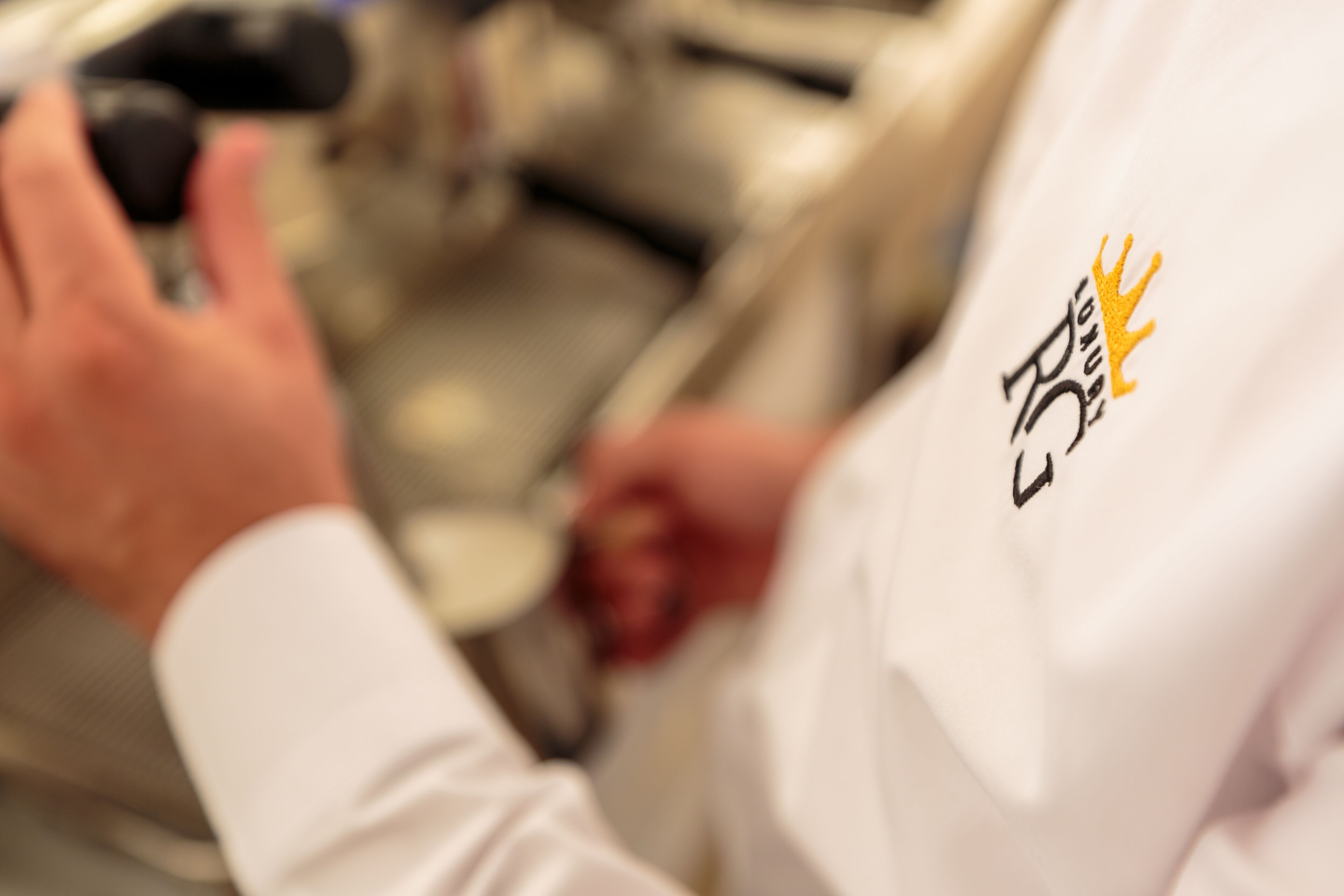 A person wearing a white shirt with a logo on the sleeve.