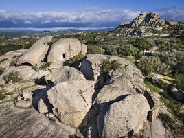 Una gran formación rocosa con una pequeña estructura similar a una cueva.