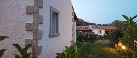 A white building with a stone facade and a window.
